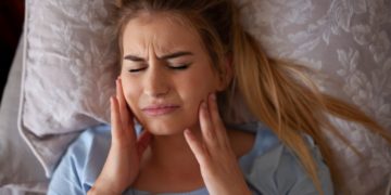 woman-lying-in-bed-with-jaw-pain