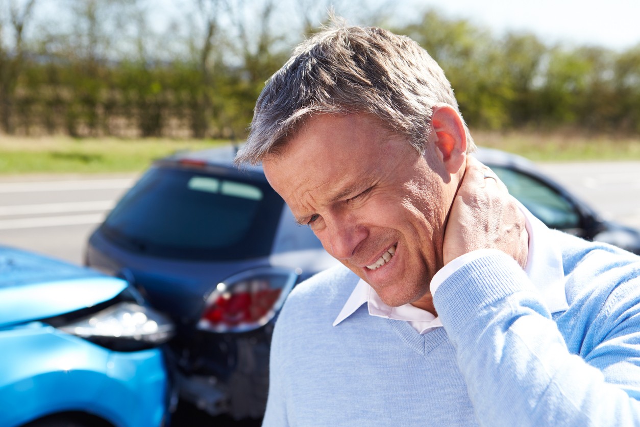 Man rubbing neck pain after a car accident. 