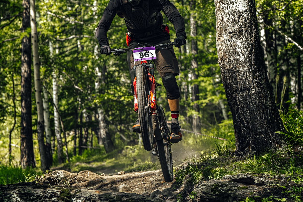 A professional mountain biker competes on a mountain trail. 