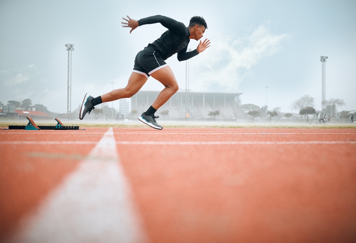 An African American runner practices sprints on a track.