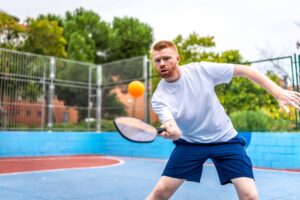 A pickleball player in the middle of play on the court.